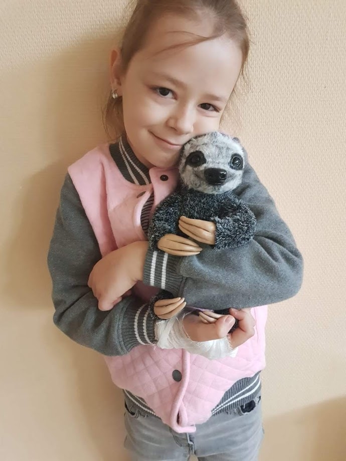 девочка с игрушкой ленивец